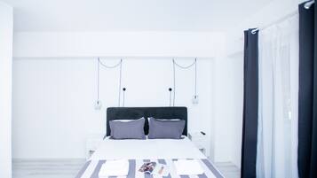 Een moderne slaapkamer met een groot bed, nachtkastjes en een nachtkast.
