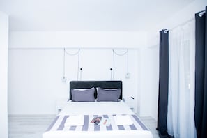Un dormitorio moderno con una cama grande, mesitas de noche y una mesita auxiliar.