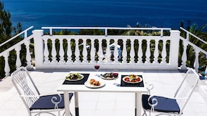 A terrace with a table set for two, overlooking a coastal view. - Bianco Olympico Beach Resort By Anayia AI Resorts (Polygyros)