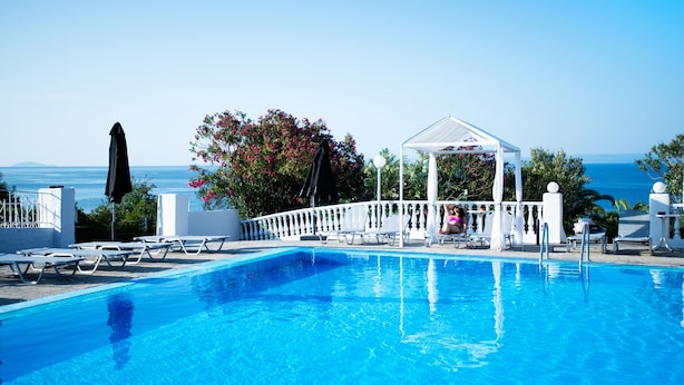 A clear blue pool with lounge chairs and a gazebo overlooking the sea. - Bianco Olympico Beach Resort By Anayia AI Resorts (Polygyros)