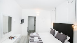 A hotel room with a bed, bedside table, and a mirror. - Bianco Olympico Beach Resort By Anayia AI Resorts (Polygyros)