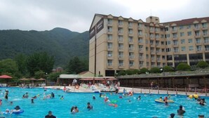 Un hotel con piscina, rodeado de montañas.