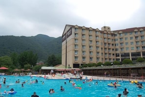 Ein Hotel mit Schwimmbeckenbereich, umgeben von Bergen.