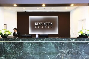 A reception desk at Kensington Resort with a marble countertop, a digital display, and a receptionist. - Kensington Resort Gapyeong (Gapyeong-gun)