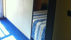 A room with a bed, a mirror, a television, and an air conditioning unit. - Hotel Le Mejean (Lattes)