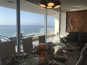 Appartement Deluxe, 2 chambres, vue océan, en bord de plage | Coin séjour | Télévision à écran plat de 49 pouces avec chaînes par câble