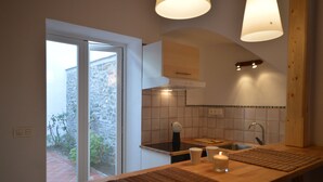 Een keuken met een houten aanrecht, een spoelbak en een raam met uitzicht op een tuin.