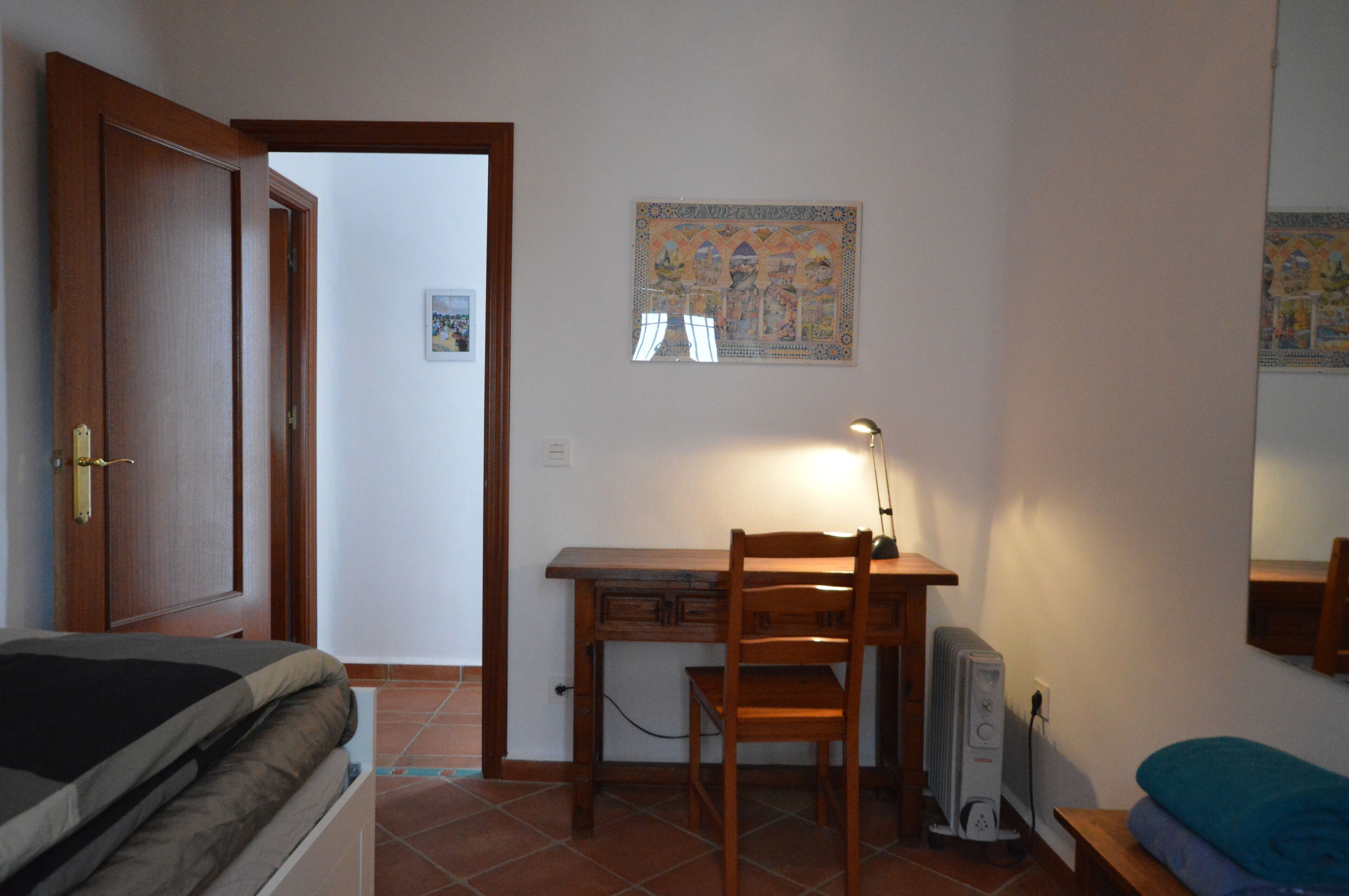 Ein Schlafzimmer mit einem Bett, einem Schreibtisch und einem Stuhl.