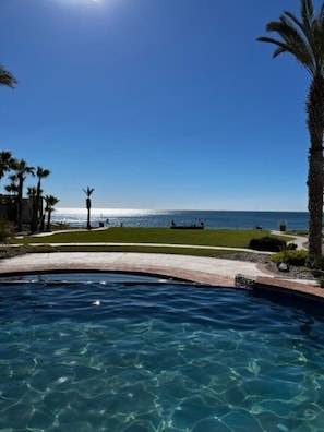A clear blue sky, a swimming pool, and a view of the ocean.
