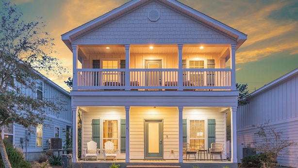 A two-story house with a balcony, a front porch with chairs, and a number '41' on the door.