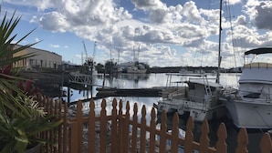 A marina with boats docked, a wooden fence, and a clear sky with clouds. - F1, Downtown St. Augustine, POOL, beaches, free onsite parking! (Saint Augustine)