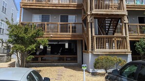 Un edificio de varios pisos con balcones de madera y acceso a un garaje.