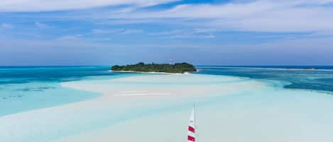 On the beach, white sand, sun loungers, beach umbrellas