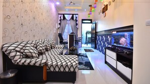 A modern bedroom with a large bed, a TV, and a ceiling fan. - Holiday Haven Ukulhas (Ukulhas)