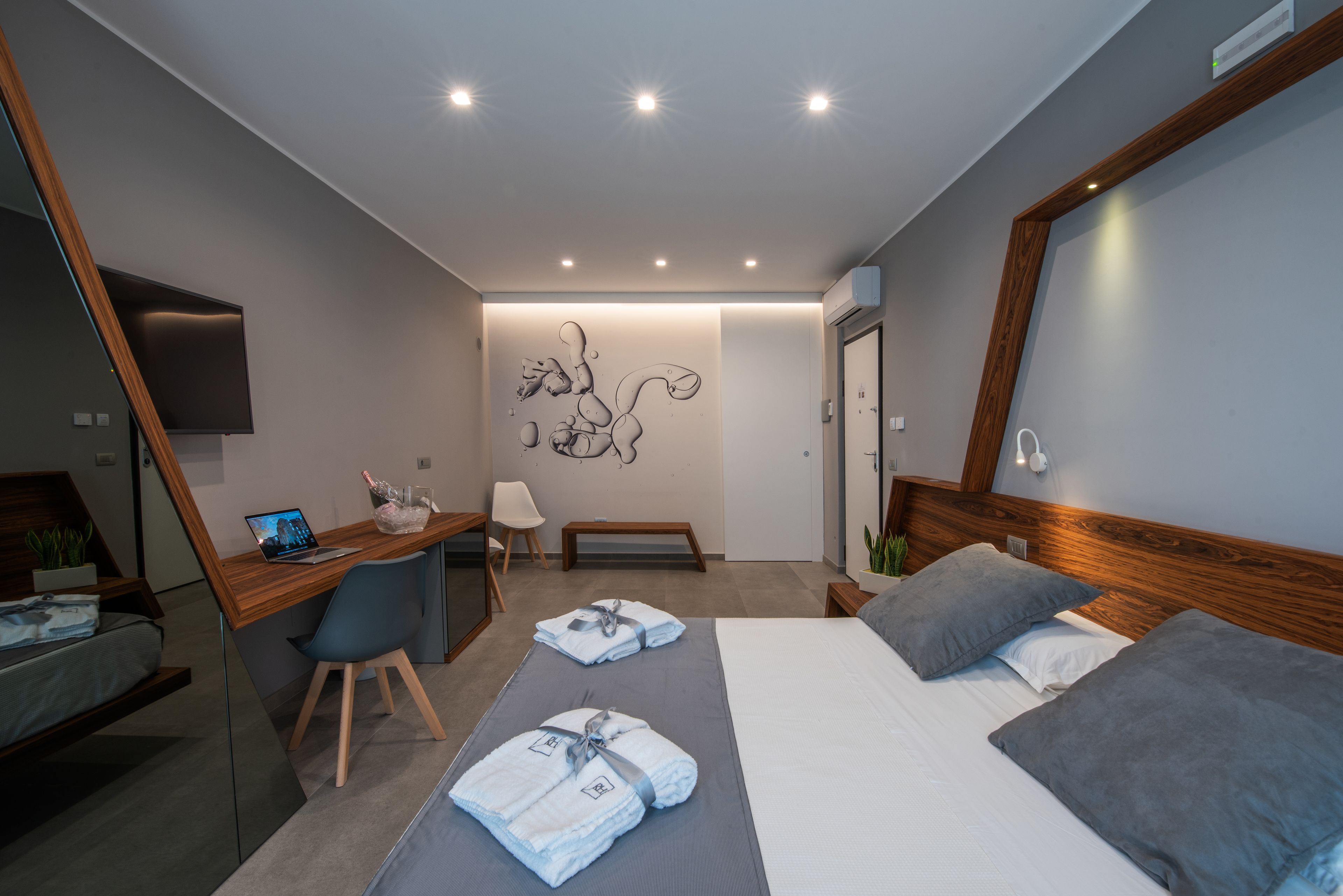 A modern hotel room with a bed, desk, and seating area.