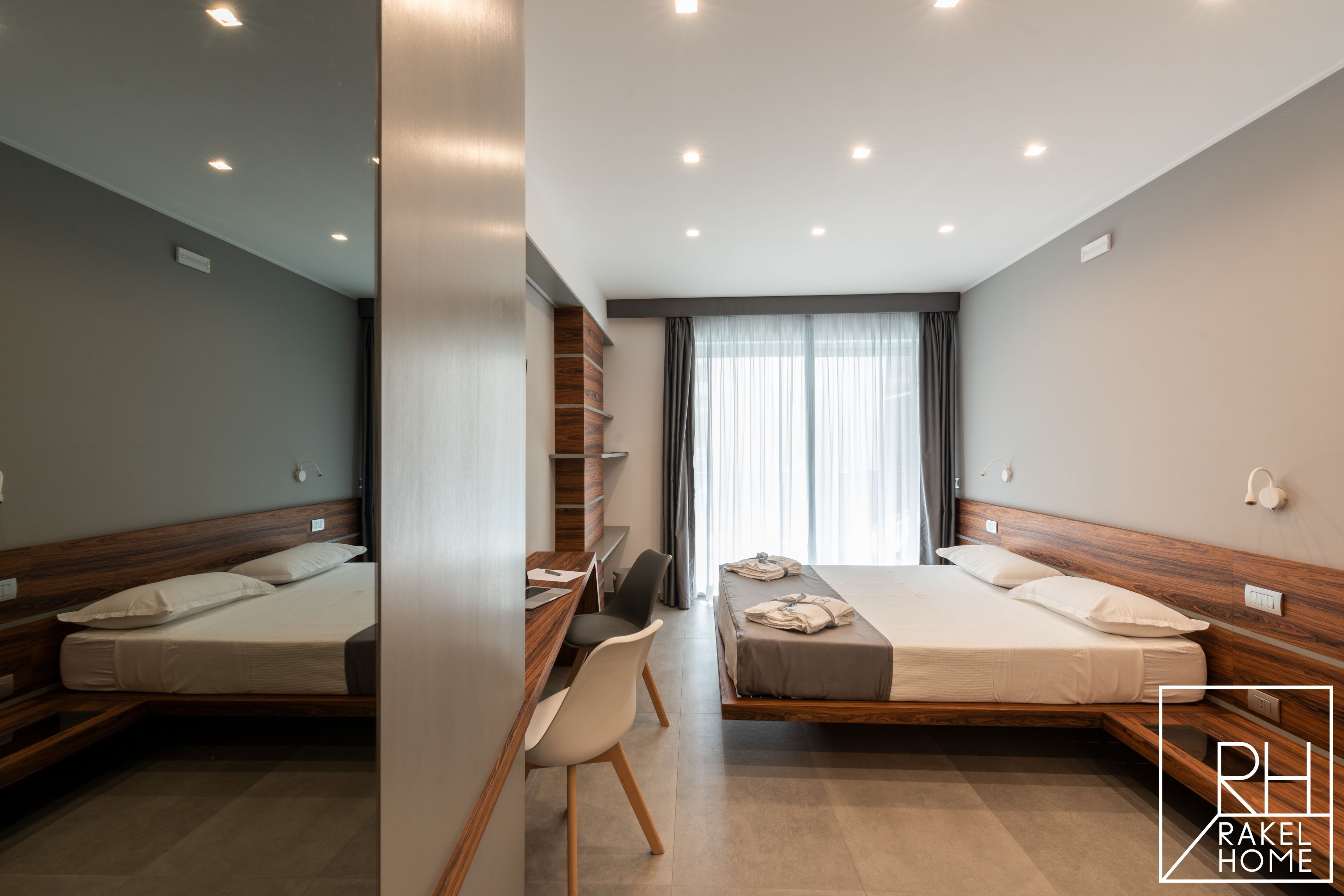 Una habitación de hotel moderna con dos camas, un escritorio y una silla.