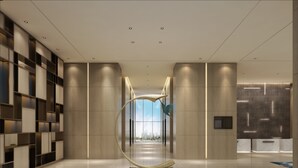 Un intérieur moderne avec une sculpture centrale, un éclairage encastré et une vue dégagée sur l’extérieur grâce à une grande fenêtre.
