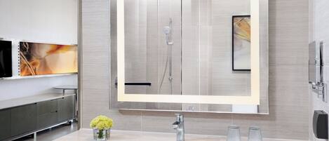 Un baño moderno con un espejo grande, un lavabo y una ducha.