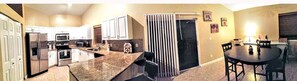 Enjoy casual meals at the central island kitchen with a dining area featuring a round table and chairs.