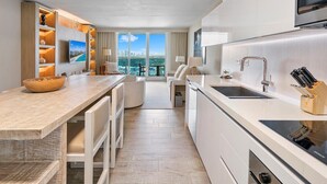 A modern kitchen with a large island, built-in appliances, and a view of the city.