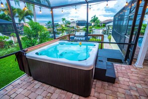 Un bain à remous sur une terrasse en briques, avec vue sur un quartier résidentiel et un grand bâtiment en verre.