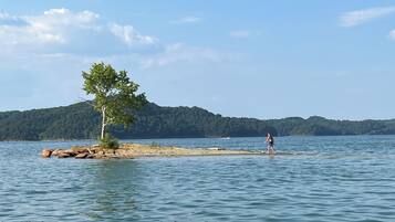 Un lac avec une petite île et une personne qui s’y promène.