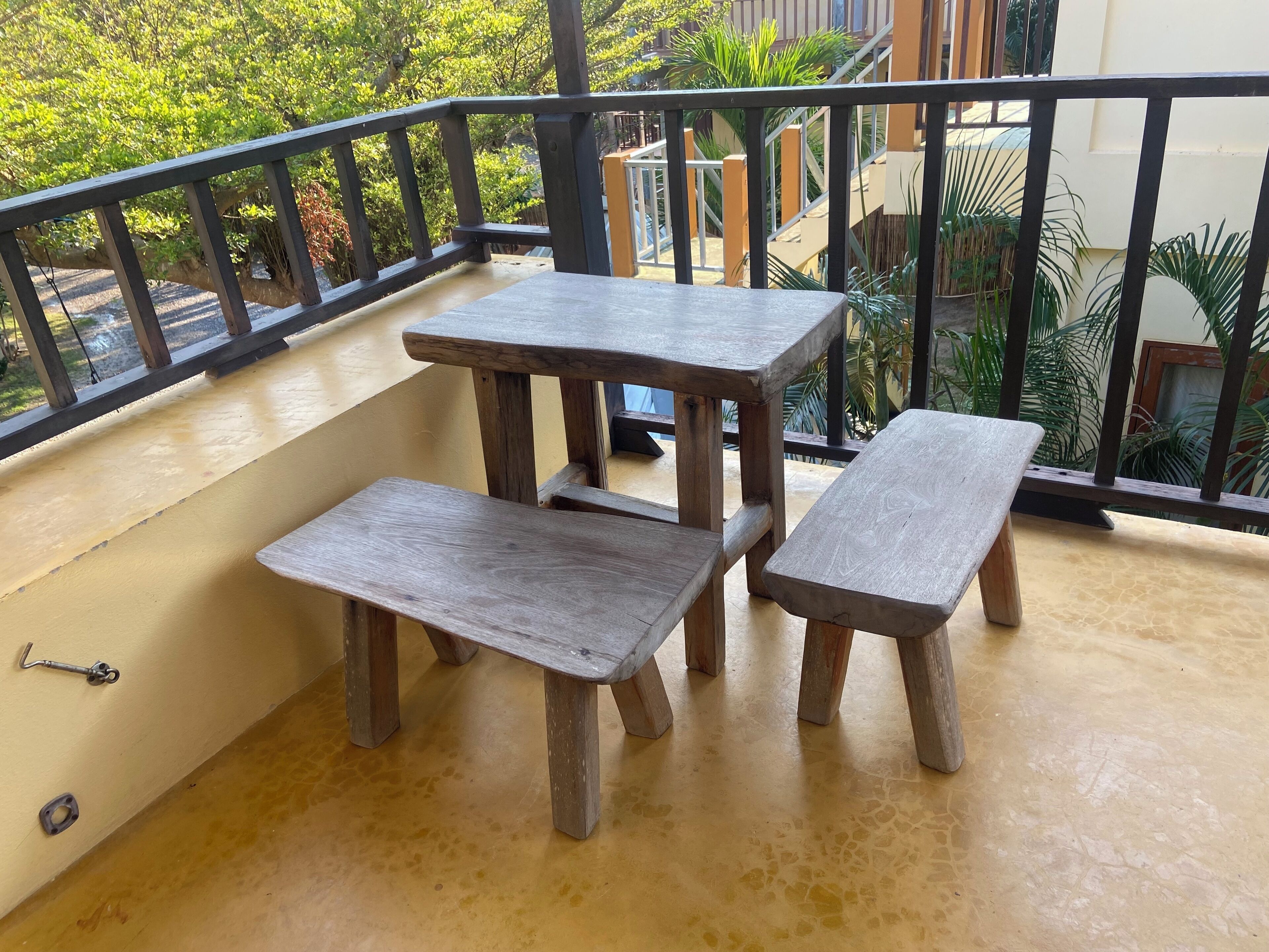 A balcony with a wooden table and two benches.
