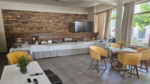 Ein moderner Essbereich mit Steinwand, einem Buffet und bequemen Sitzgelegenheiten.