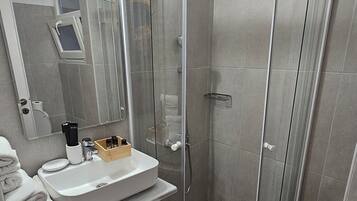 Shower, designer toiletries, hair dryer, slippers