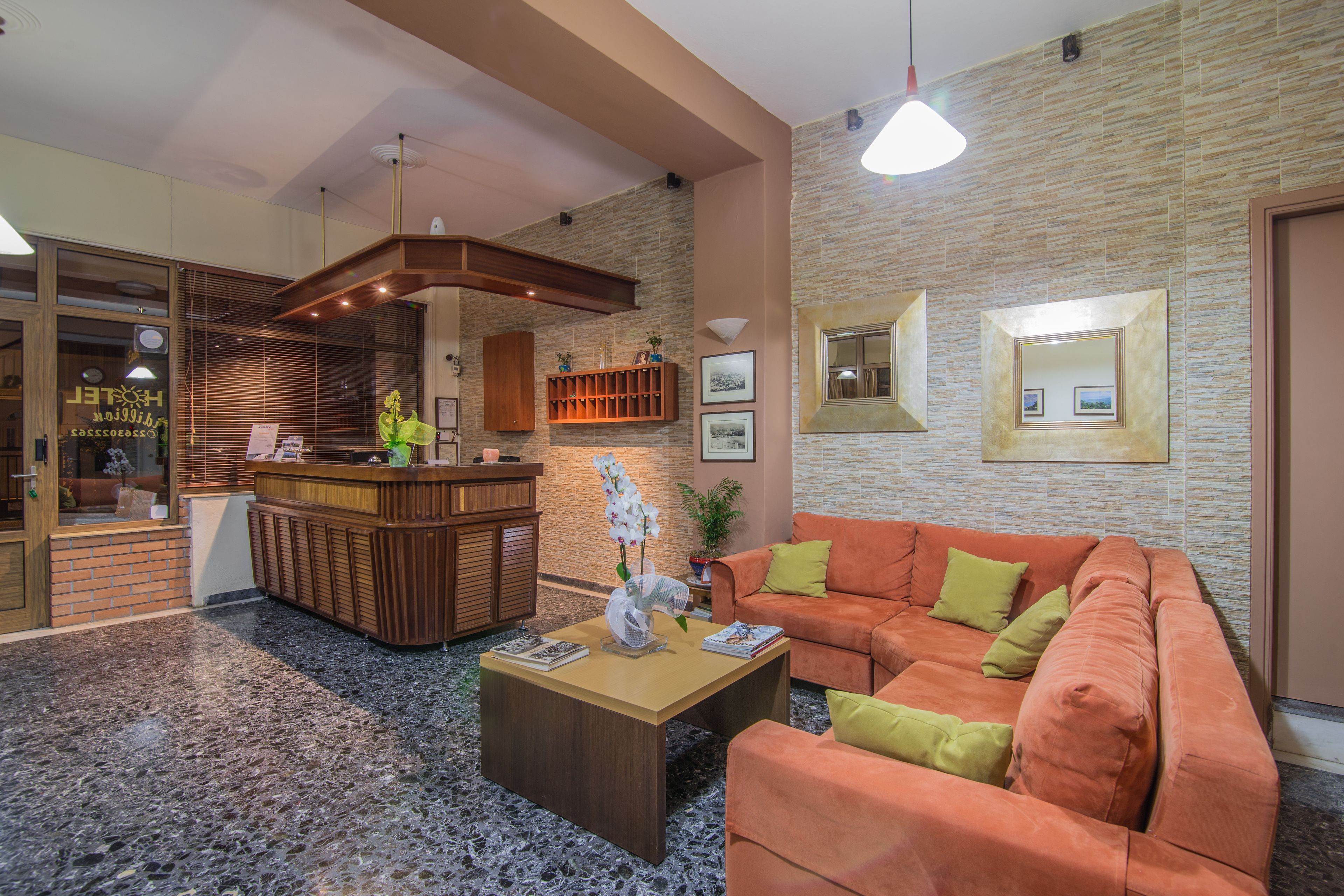 A lobby with a reception desk, a sofa, a coffee table, and a stone-patterned floor.