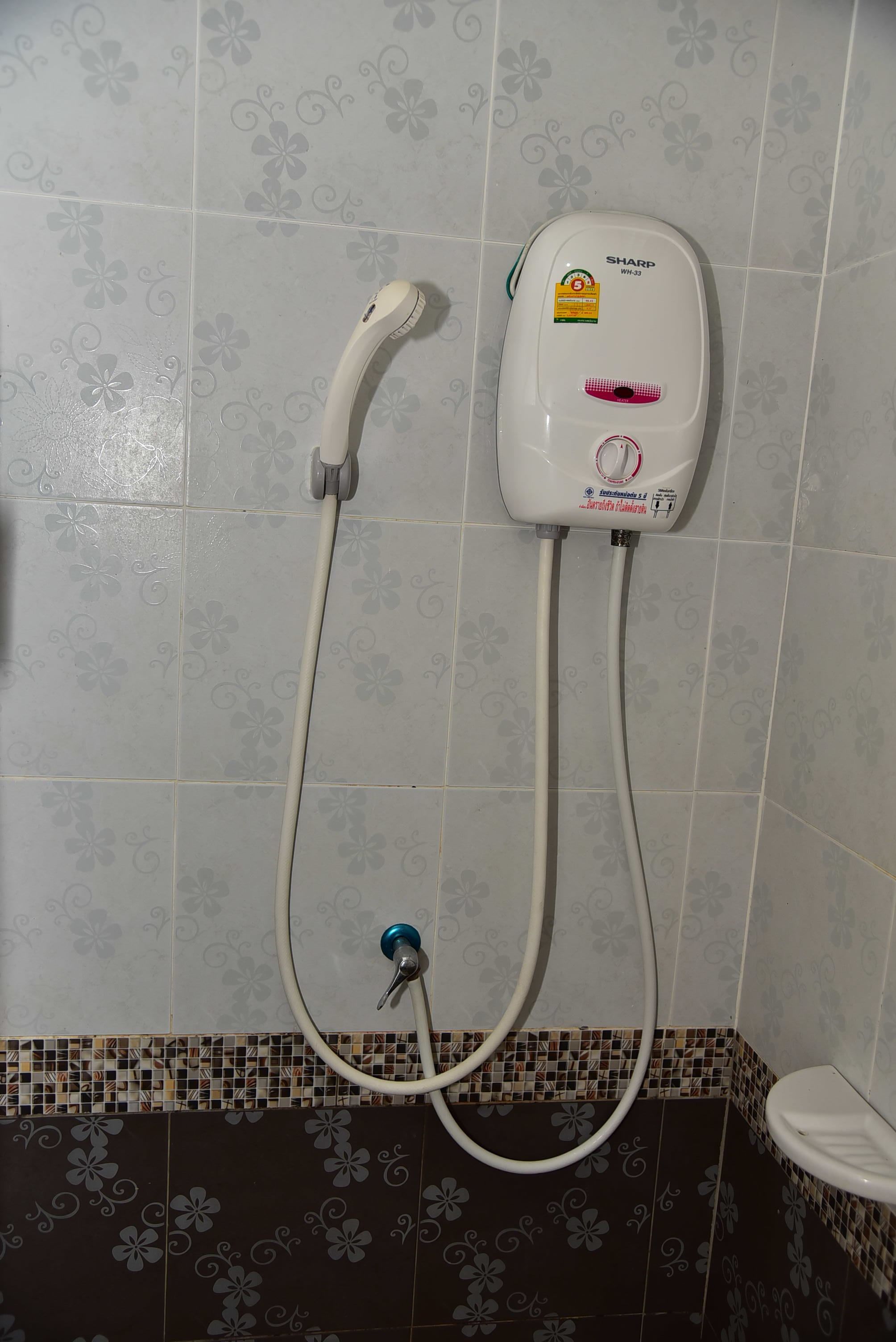 Ducha con cabezal de ducha de mano y controles en la pared.