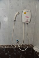 Ducha con cabezal de ducha de mano y controles en la pared.
