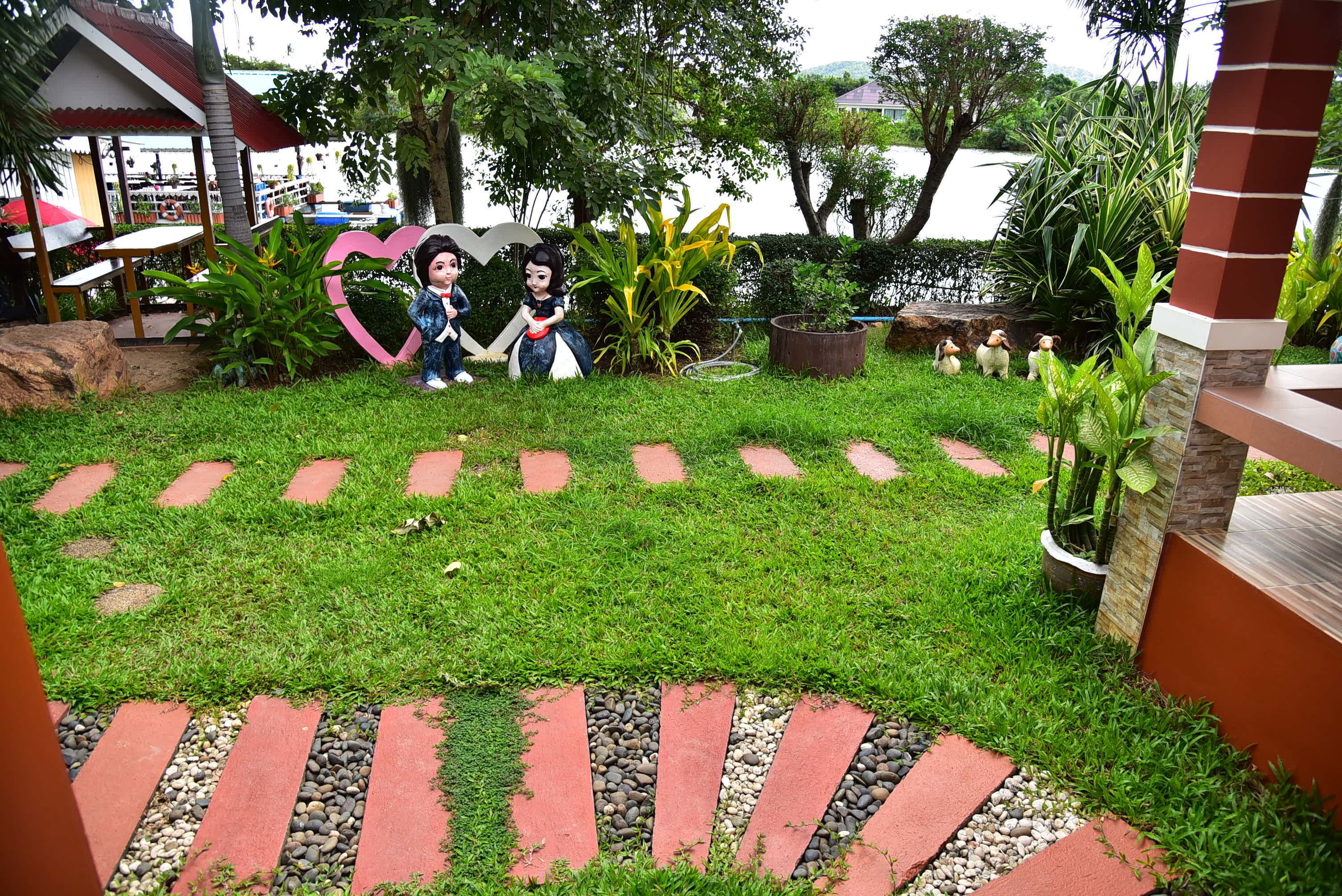 A garden area with a heart-shaped decoration, a small pond, and a gazebo.
