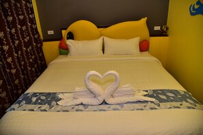 A hotel room with a bed, a heart-shaped towel arrangement, and a floral-patterned bedspread. - Pranwimol Resort (Pranburi)