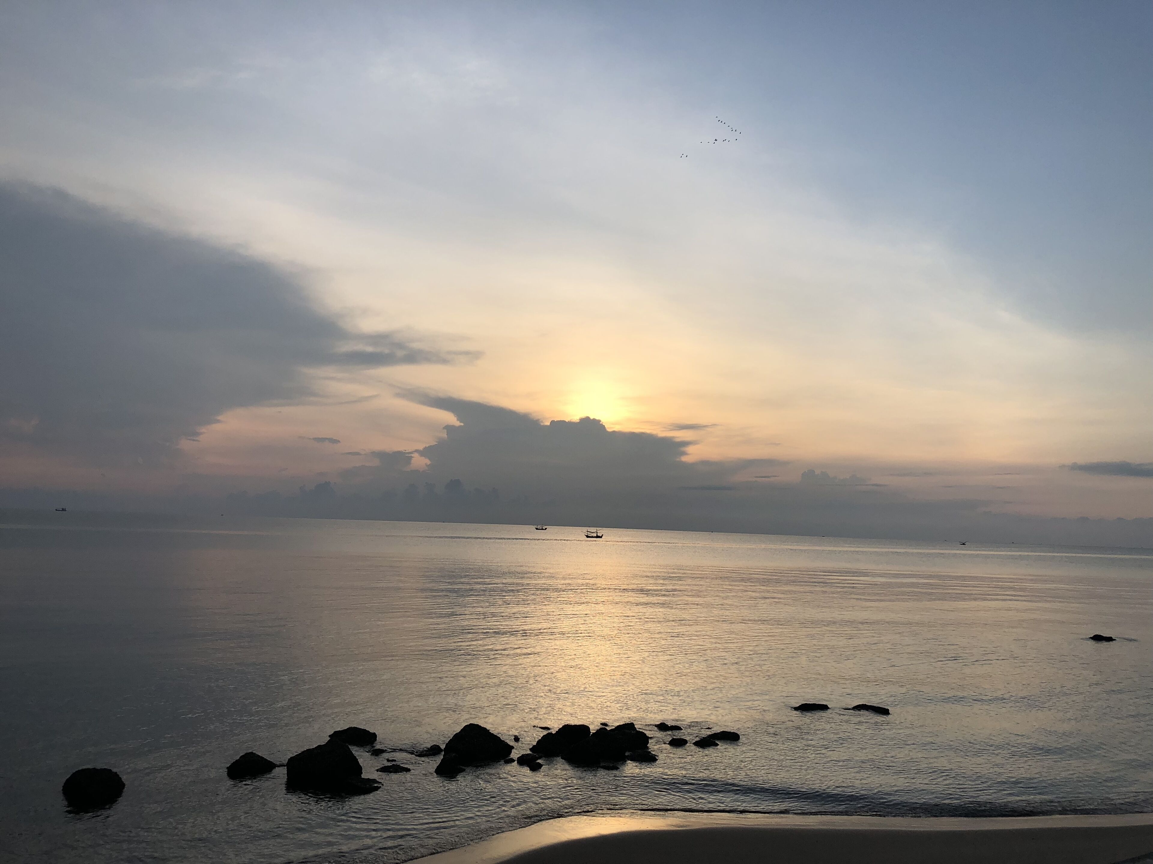 Ein ruhiges Meer, in der Ferne ein Boot und ein klarer Himmel.