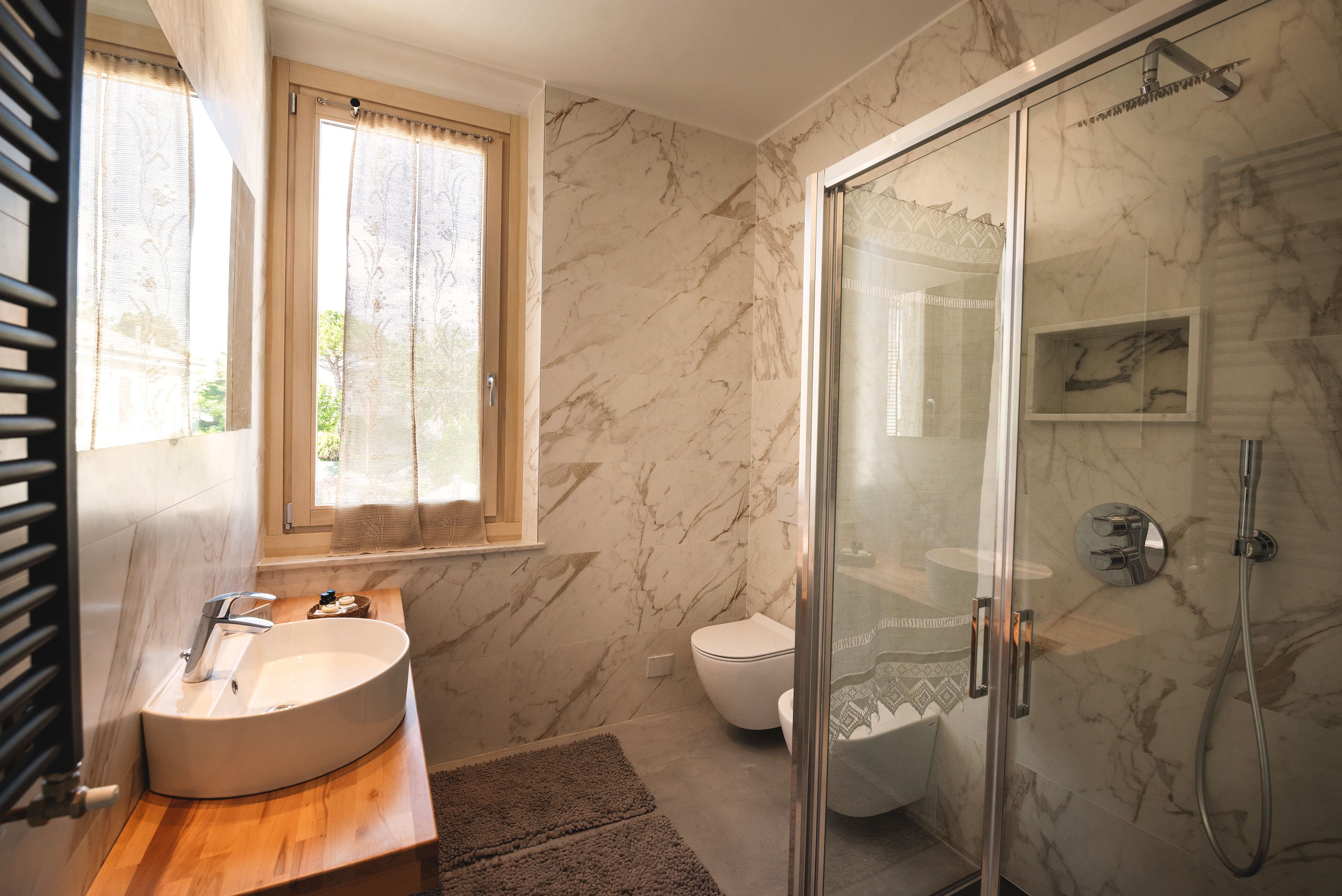 Familie driepersoonskamer | Badkamer | Een douche, een regendouche, designer toiletartikelen, een haardroger