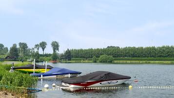 A calm lake with three boats docked at the shore.