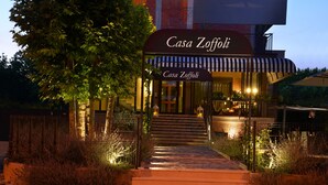 A hotel entrance with a sign reading "Casa Zoffoli," steps leading up to the entrance, and outdoor seating area with tables and chairs. - Hotel Loretta & Dependance (Cervia)