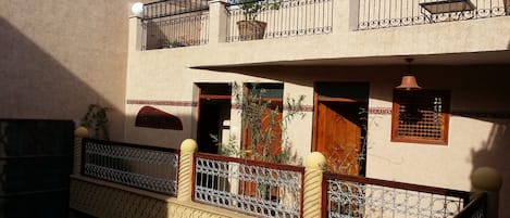 A multi-story building with balconies, decorative railings, and a traditional design.