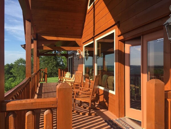 Relax on the covered deck with comfortable seating and a glass door leading to the interior.