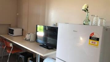 A compact kitchenette with a microwave, toaster, and Haier refrigerator.