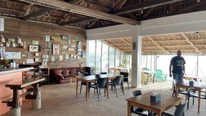 A rustic cafe with wooden walls, a bar area, and tables and chairs for dining. - Footprints Beach Resort (San Andres)