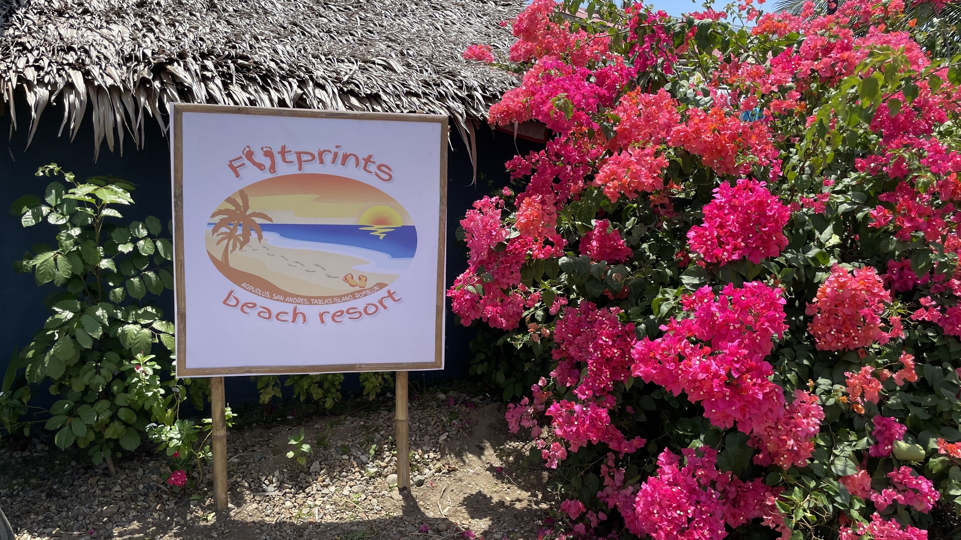 A sign for 'Flintprints Beach Resort' with a beach scene illustration.