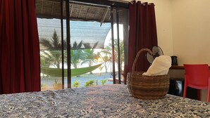 A room with a view of palm trees and a hammock by the window. - Footprints Beach Resort (San Andres)