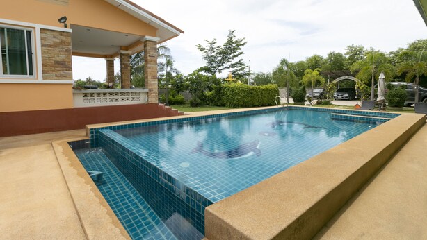 A rectangular swimming pool with blue tiles, surrounded by a concrete deck. - OYO 949 Sansuk Resort Paknampran (Pranburi)