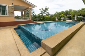 A rectangular swimming pool with blue tiles, surrounded by a concrete deck. - OYO 949 Sansuk Resort Paknampran (Pranburi)