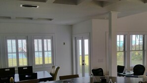 A spacious room with large windows, a high ceiling, and a modern design. - Romantic Escape; Open Gulf View; Your Own Private Dock!  Elevator to master. (Crystal Beach)