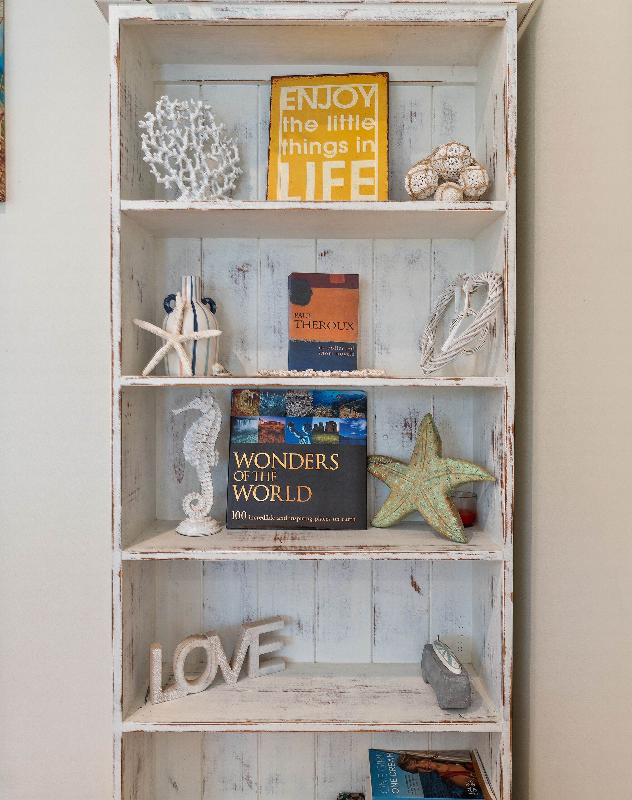 Una libreria con diversi oggetti decorativi e libri.