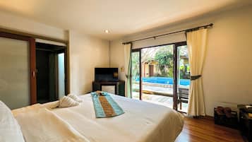 A hotel room with a large bed, a TV, and a view of a swimming pool.