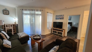 Una sala de estar con un sofá, una mesa de centro, un televisor y un cuadro en la pared.